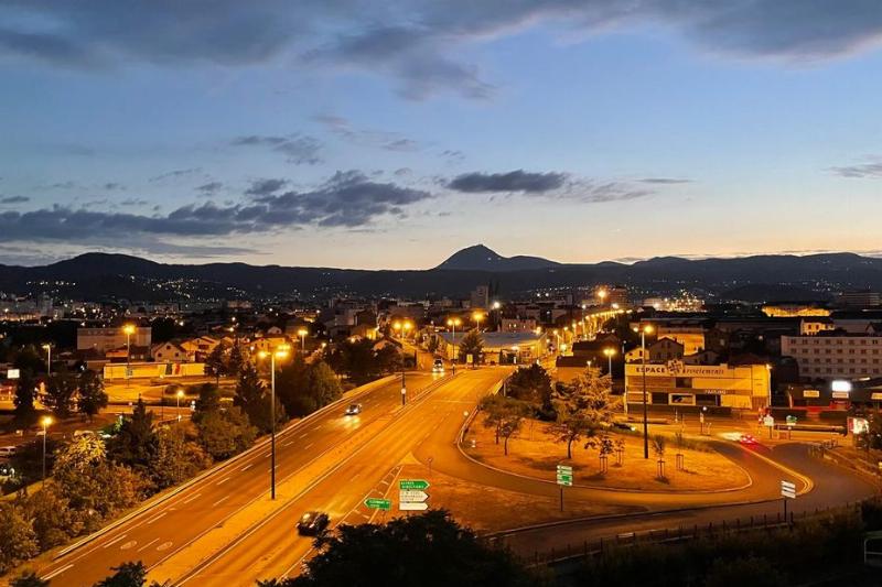 Terrasse animée d’un restaurant de Clermont-Ferrand avec vue sur la cathédrale, au coucher du soleil